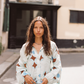 Close-up of model wearing Kinga Csilla Aquarius Chalm Shirt in light linen with celestial-inspired geometric print, styled with loose waves and sunglasses in hand