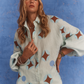 Close-up of model wearing Kinga Csilla Aquarius Chalm Shirt in linen with geometric print, photographed against a blue backdrop
