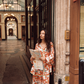 Model wearing Kinga Csilla Farfalla Chalm Shirt and Jessi Pant in orange butterfly print, oversized co-ord set styled with city map for Paris travel outfit