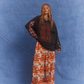 Model in Kinga Csilla Love Potion Roses Tee stonewashed black with graphic rose print, styled with Farfalla Jessi Pant in orange butterfly cloud motif.