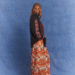 Model wearing Kinga Csilla Love Potion Roses Tee in stonewashed black with mystical rose artwork, styled with Farfalla Jessi Pant in bold orange butterfly print