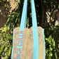 Front view of Kinga Csilla Rainy Lace KC Shoulder Bag with aqua blue straps and logo embroidery, featuring intricate sage lace body, lightweight artisanal tote.