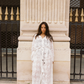 Model wearing the Kinga Csilla Tottori Lace Harlow Maxi white maxi dress, sheer cotton embroidery with adjustable drawstring cuffs and relaxed fit.