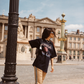 Model wearing Kinga Csilla Twilight Velvet Flare Pant in golden stretch velvet with KC logo piping, styled with oversized Kinga Csilla Sunset tee, photographed in a Paris street setting.